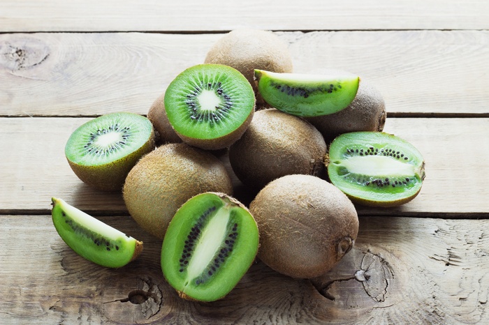 Pile of Kiwis on Wooden Surface 4K