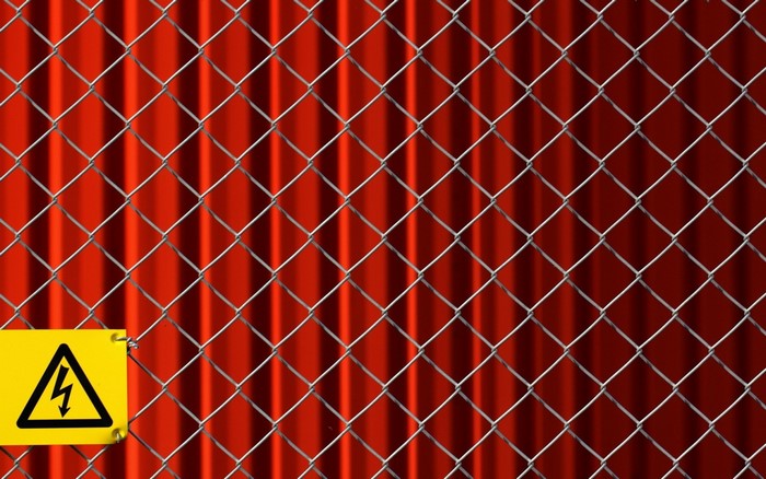 Chain-link fence with a high voltage warning sign