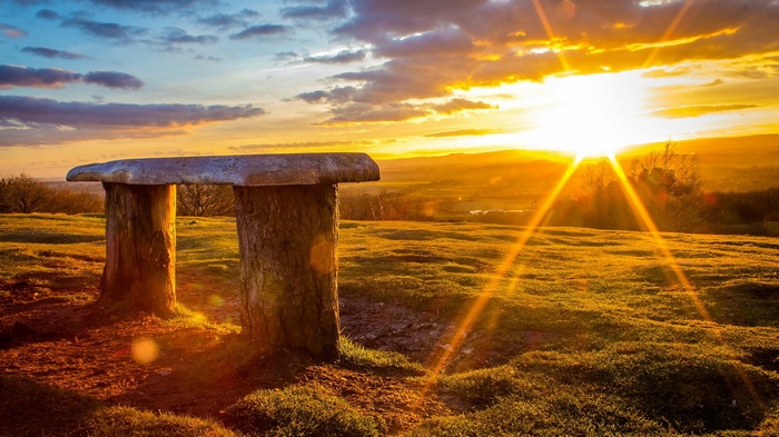 Stone bench at sunset overlooking a valley