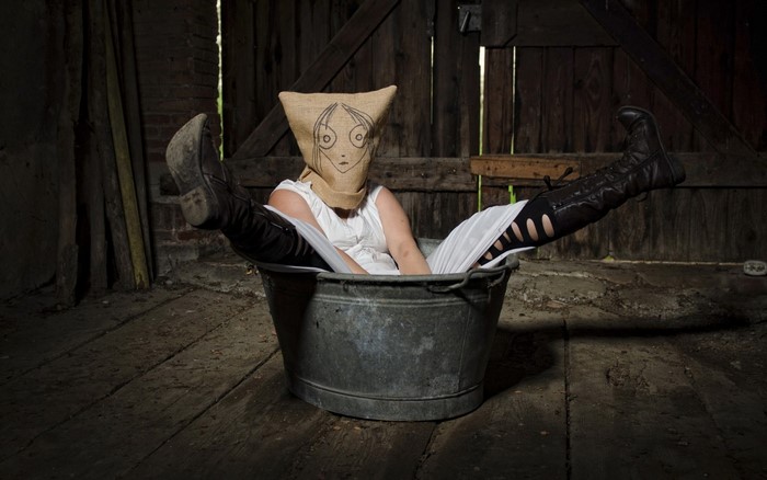 Woman in bucket with burlap sack head