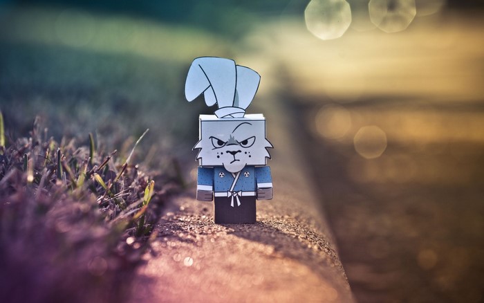 Papercraft rabbit samurai toy on a curb