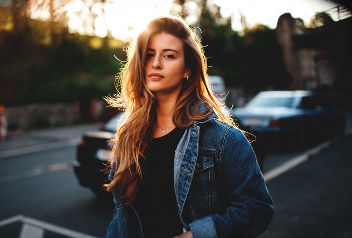 Woman in denim jacket with sun flare