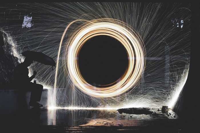 Silhouette with umbrella and light painting circle