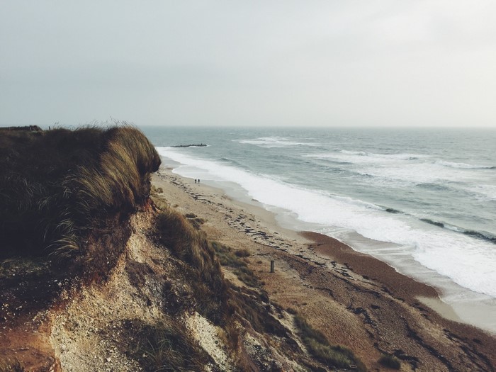 Coastal cliff overlooking a sandy beach and ocean waves