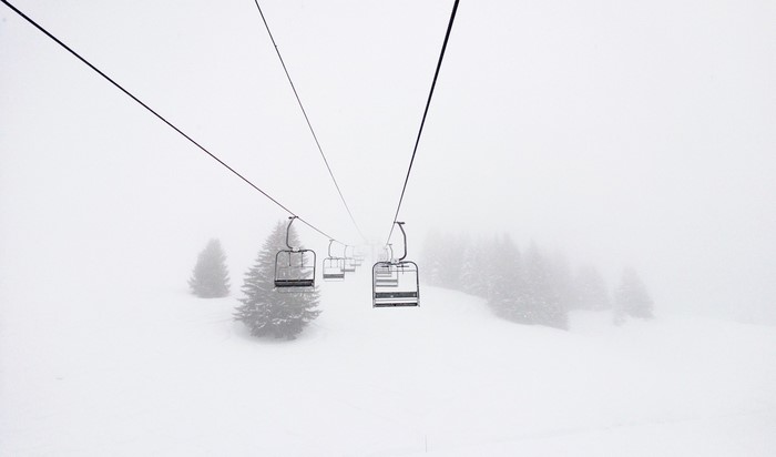 Ski lift in a snowy, misty winter landscape