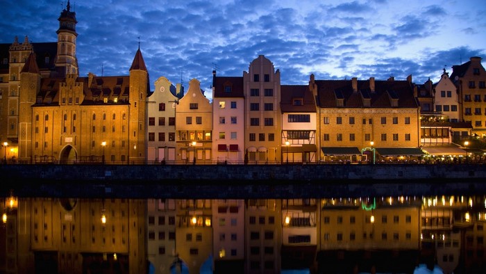 Gdańsk waterfront buildings at dusk with reflections