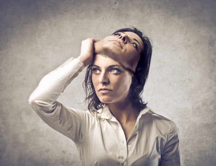 Woman holding a mask over her face