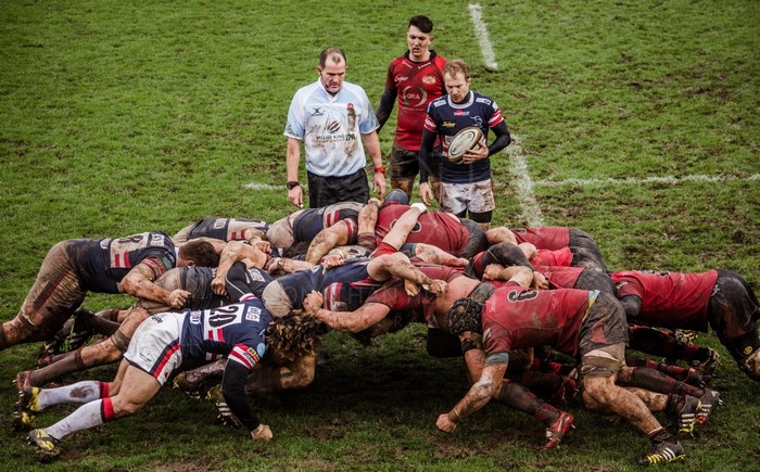 Rugby players in a scrum with referees
