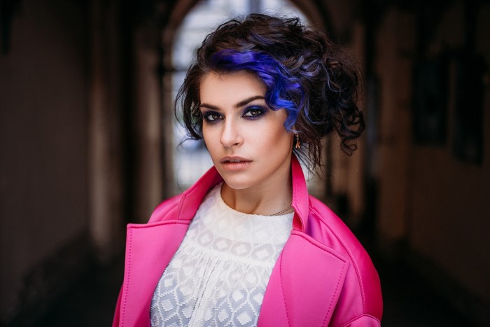 Woman with dyed hair and pink coat portrait