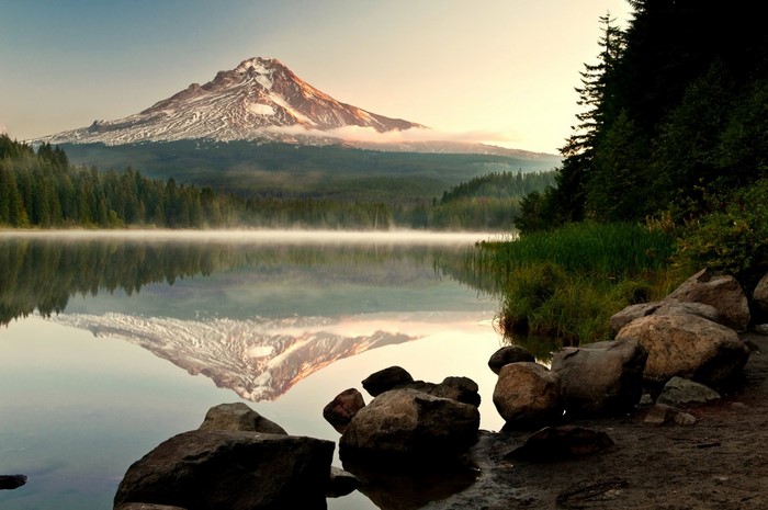Mountain reflection on a misty lake at sunrise