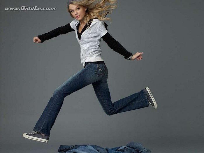 Taylor Swift jumping in jeans and hoodie
