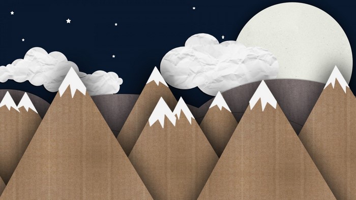 Paper cutout mountains under a starry night sky with moon and clouds