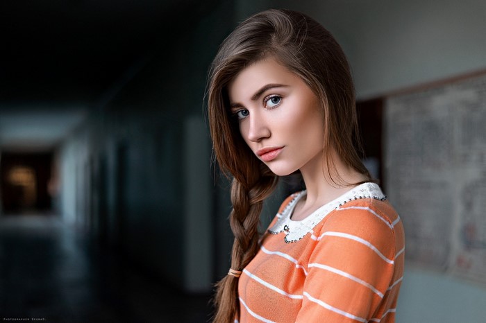 Woman with brown hair in a braid, orange and white striped shirt