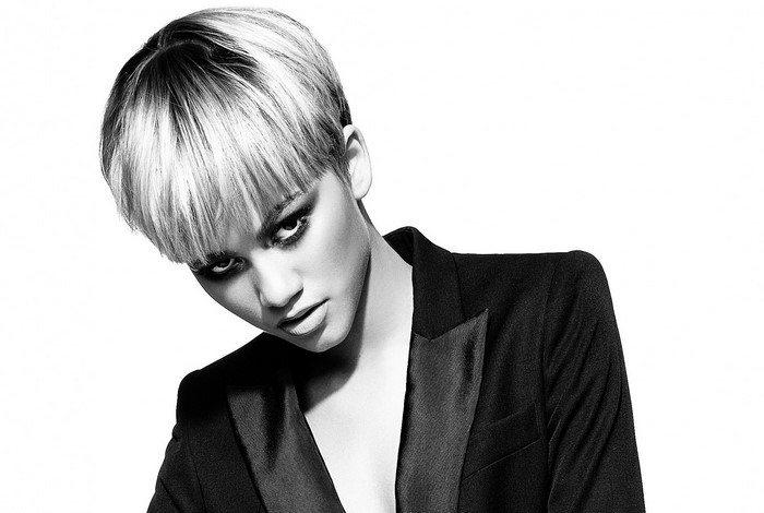 Woman with short blonde and black hair wearing a black blazer