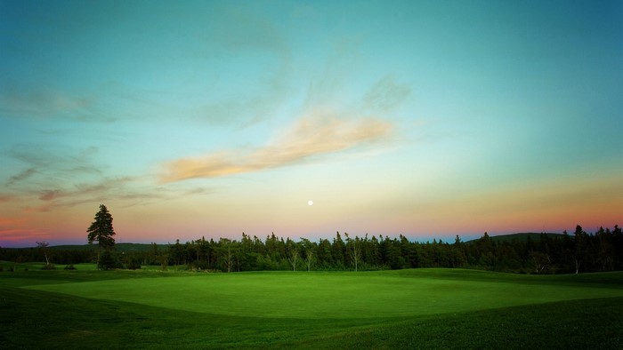 Golf course at sunset with a full moon