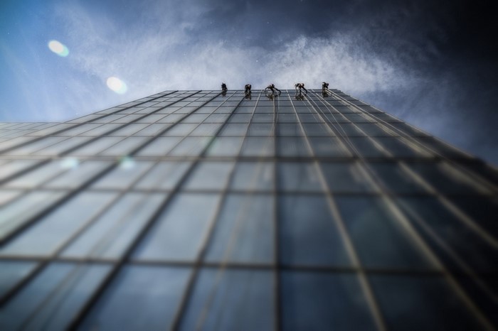 Window cleaners rappelling down a glass skyscraper