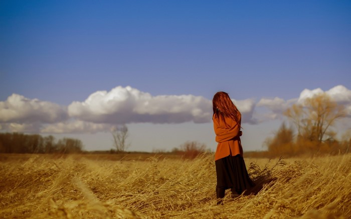 Woman in a field under a blue sky