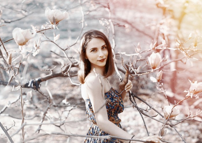 Woman in floral dress among blooming branches