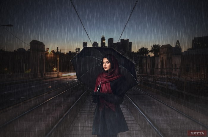 Woman with umbrella in the rain at night