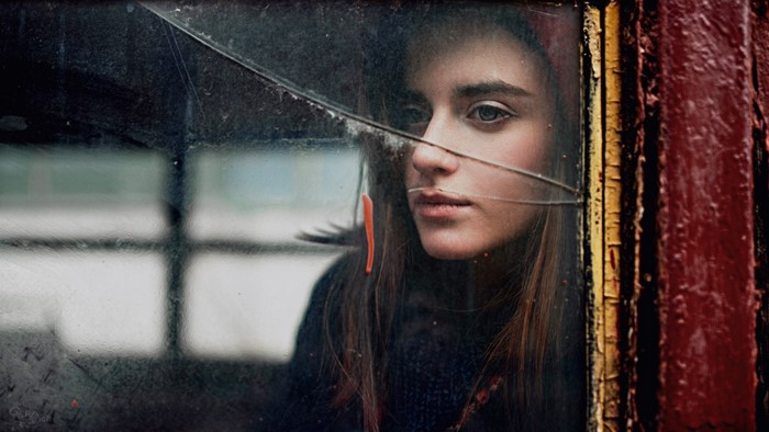 Woman looking through a cracked window