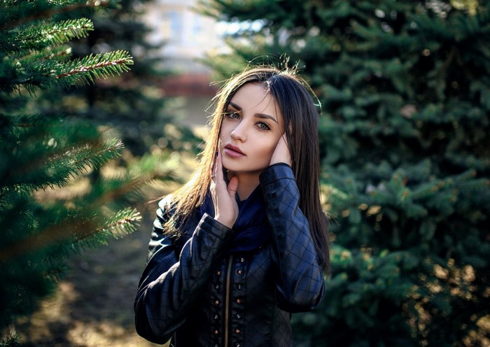 Woman with brown hair in a black jacket outdoors