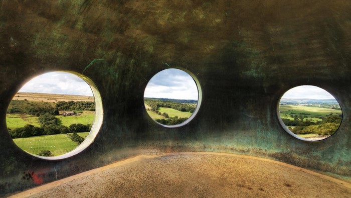 View of a rural landscape through circular openings in a structure