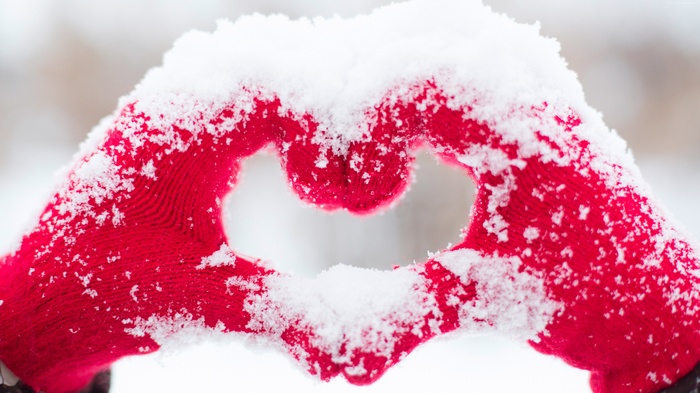 Red gloves forming a heart shape in snow, 4K