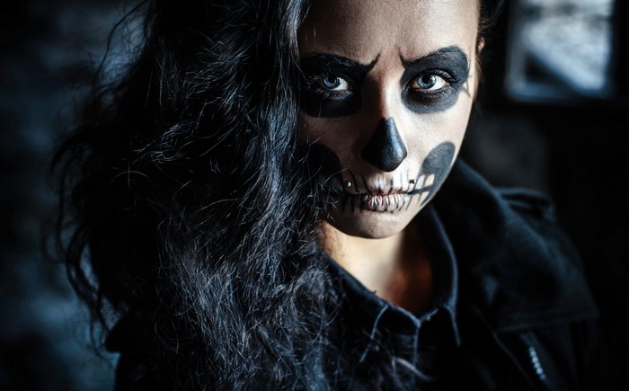 Woman with skull face paint and piercings