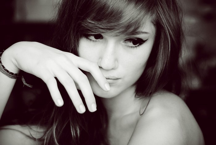 Monochrome portrait of a young woman with hand near face