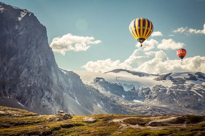 Hot air balloons over snowy mountains in Iceland
