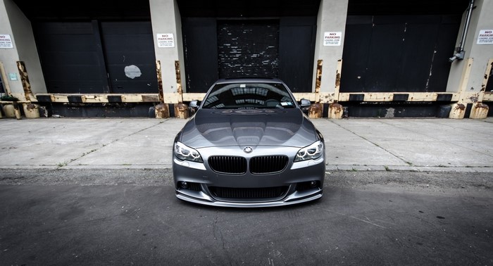 Gray BMW 5 Series Sedan parked in front of loading docks