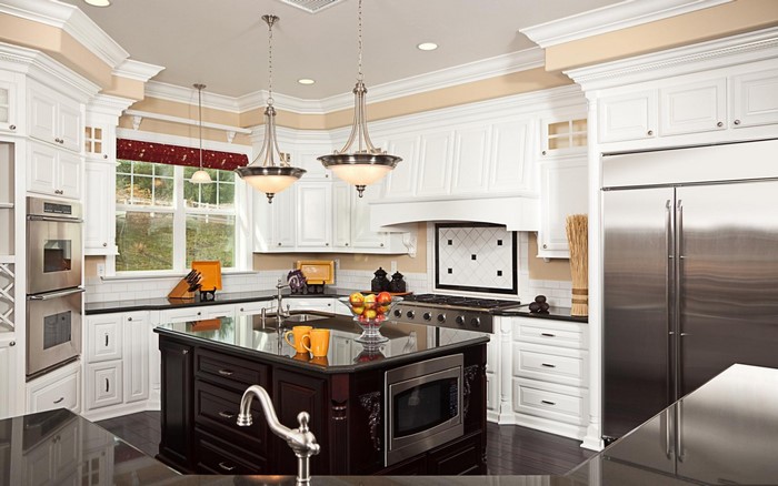 Luxury white kitchen with dark island and stainless steel appliances