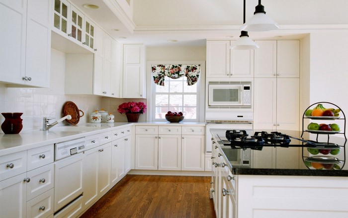 White kitchen with hardwood floors and granite countertops