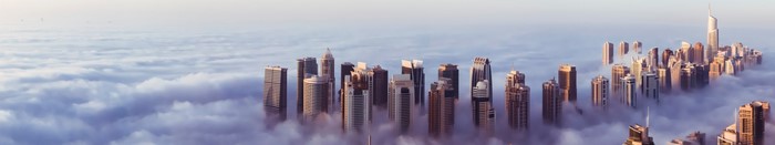 Dubai skyscrapers emerging from clouds at sunrise