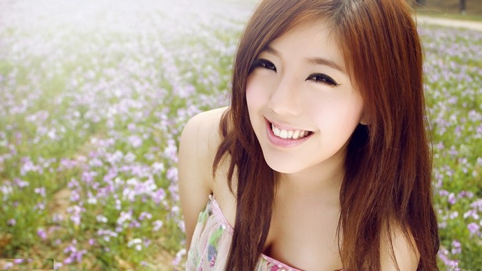 Young Asian woman smiling in a field of flowers