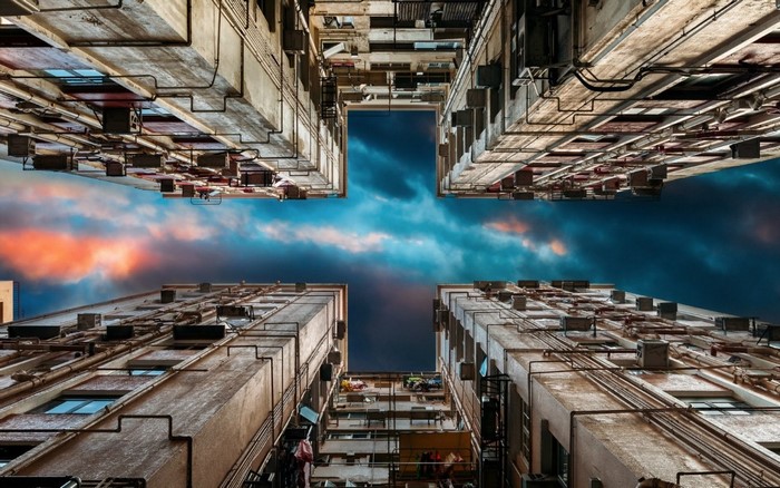 Looking up at apartment buildings against a cloudy sky