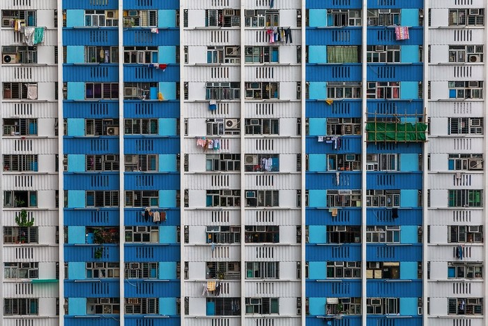 Blue and white apartment building facade with many windows