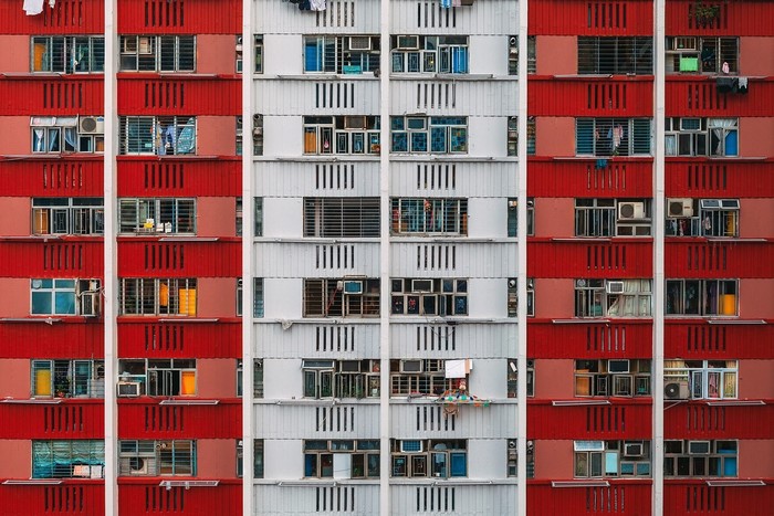 Red and white apartment building facade with many windows