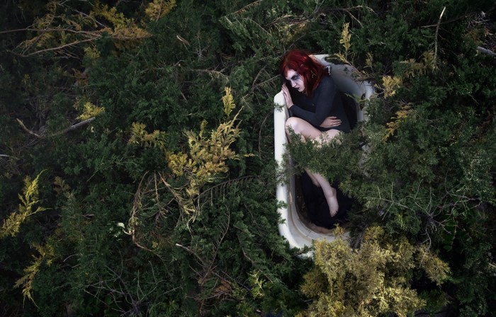 Woman in bathtub in forest