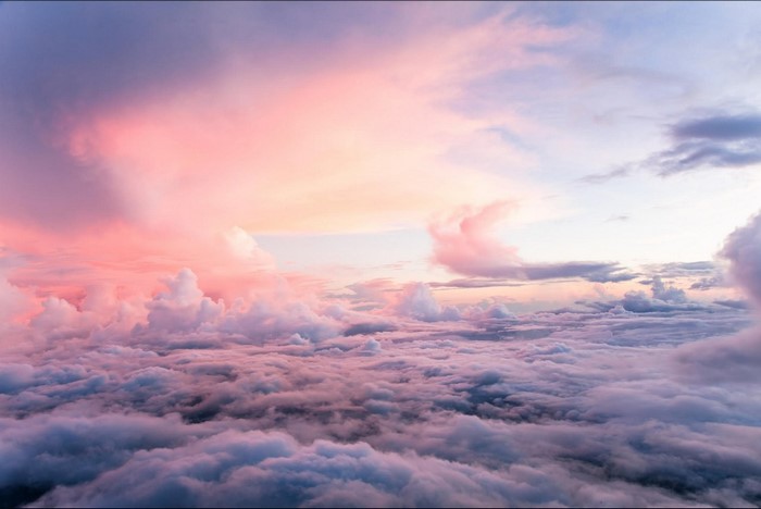 Pink and purple clouds at sunset over a sea of clouds