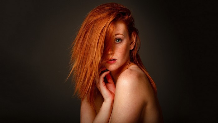 Woman with red hair and freckles posing
