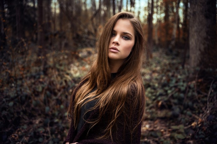 Woman with long brown hair in a forest