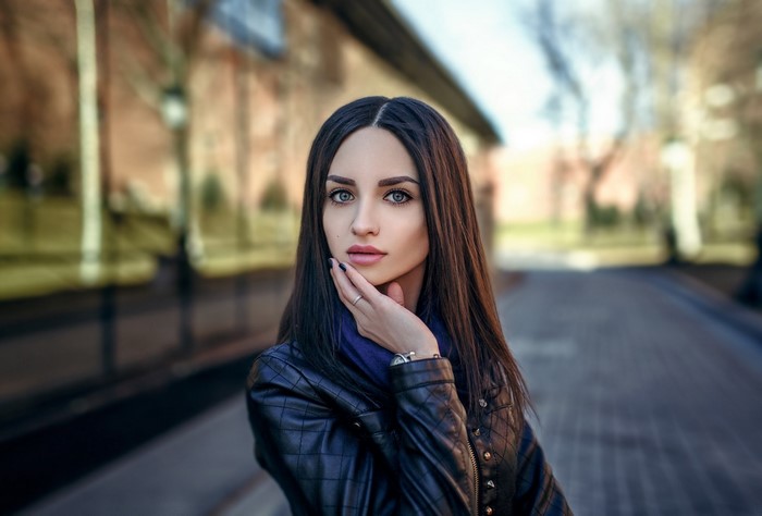 Woman with long brown hair wearing a leather jacket