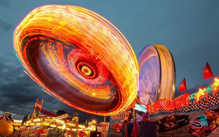 Amusement park rides at night with light trails