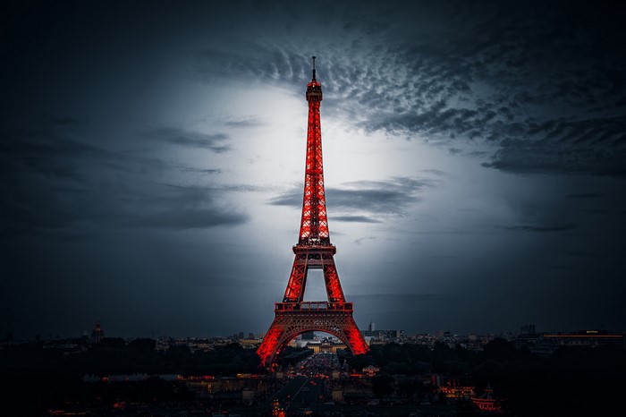 Eiffel Tower illuminated in red at night over Paris cityscape