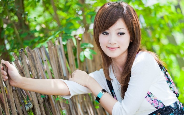 Asian woman with long brown hair smiling outdoors