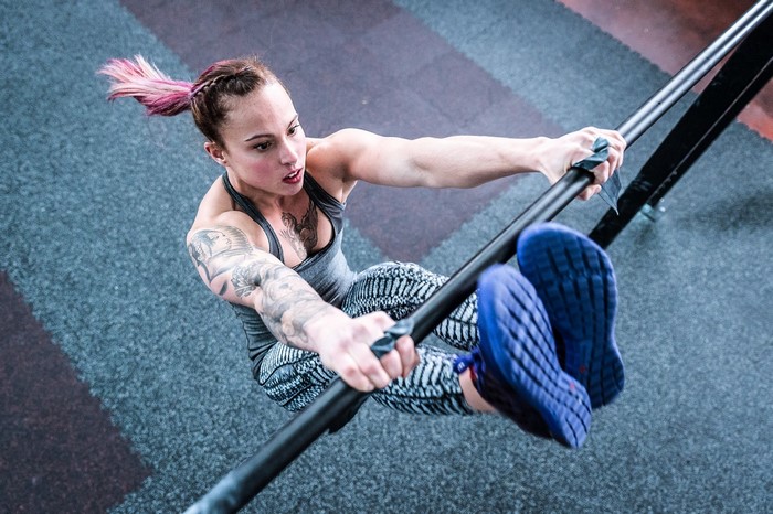 Woman performing a pull-up on parallel bars