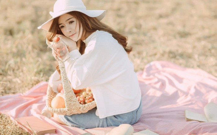 Asian woman in white hat and shirt having a picnic