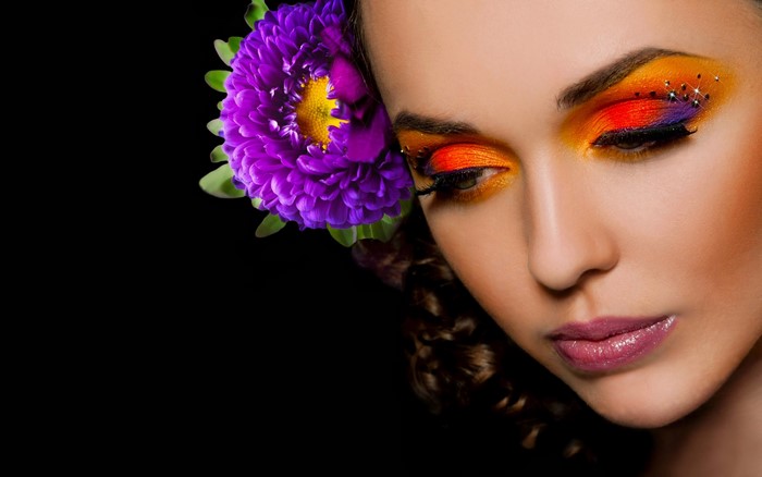 Woman with purple flower and colorful eye makeup