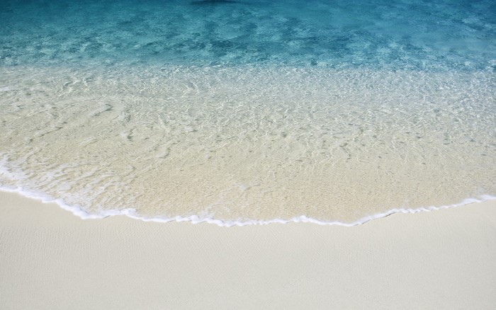 Clear ocean water washing onto a sandy beach